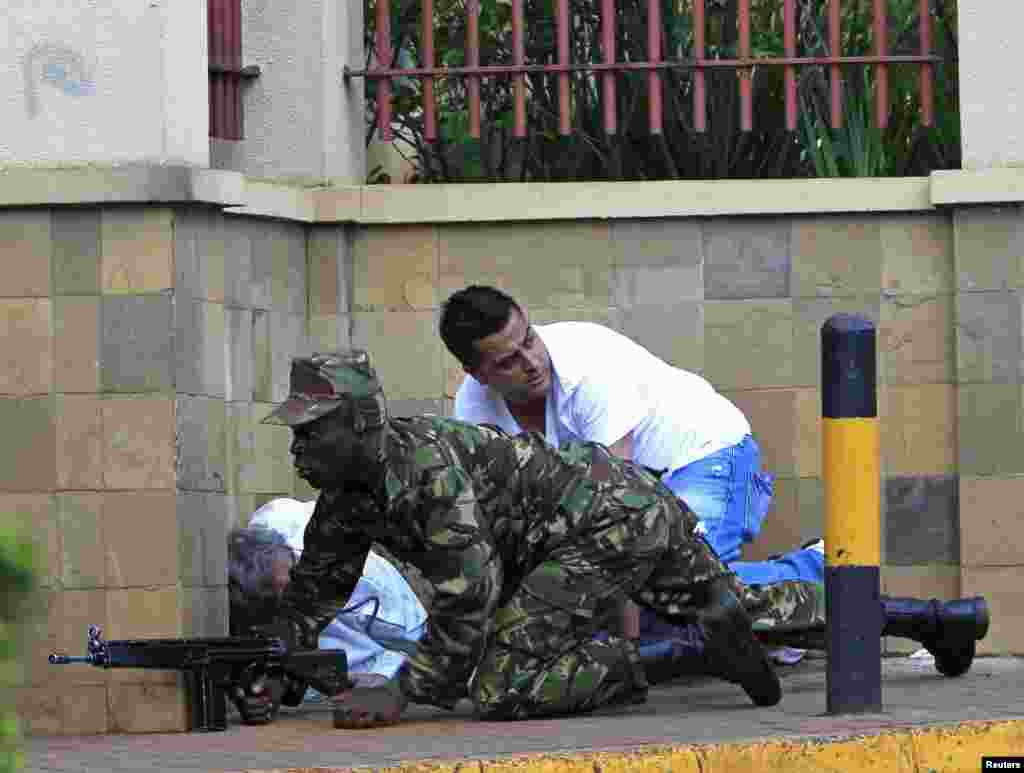 Seorang tentara Kenya merangkak di belakang tembok pusat perbelanjaan Westgate di Nairobi (21/9). (Reuters/Noor Khamis)