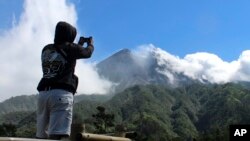 Seorang pengunjung menggunakan kamera ponsel untuk mengambil foto Gunung Merapi di Cangkringan, Yogyakarta, Selasa, 22 Mei 2018.