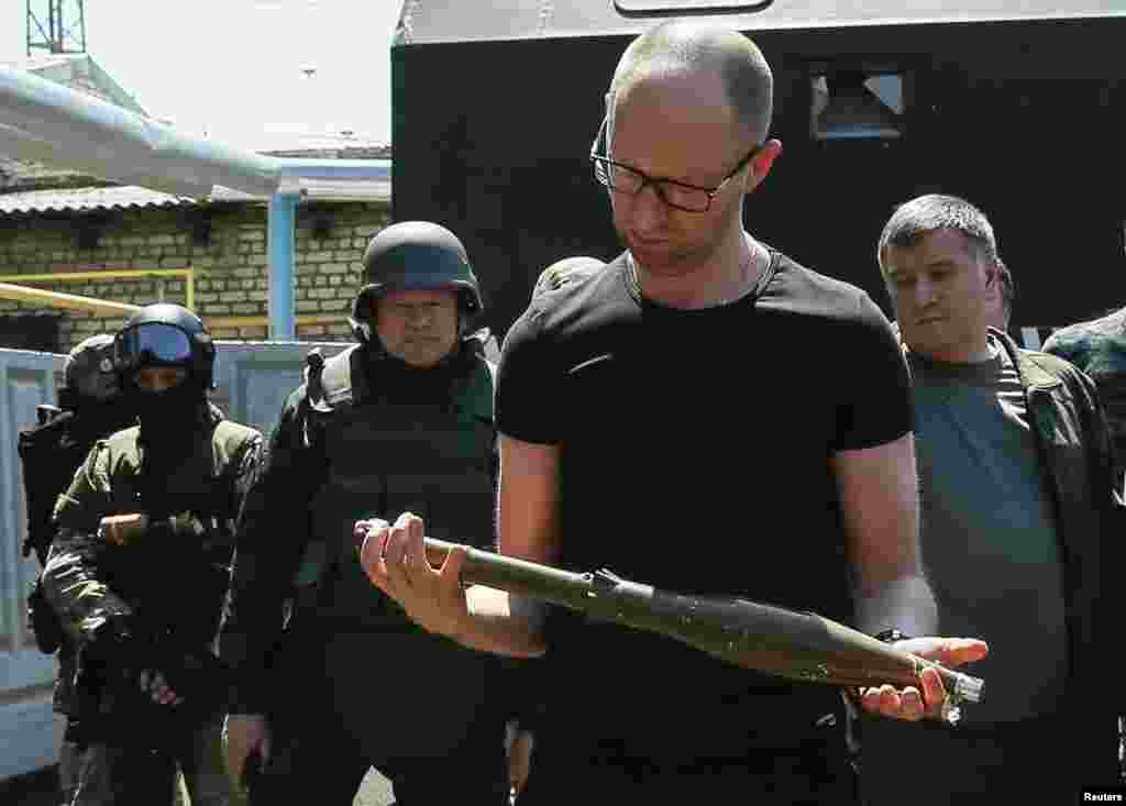 Prime Minister Arseny Yatseniuk inspects weapons seized from pro-Russian separatists as he meets with Ukrainian servicemen in the eastern town of Slovyansk, July 16, 2014.