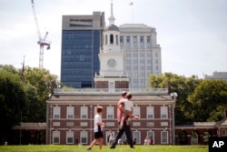FILE - People move past Independence Hall at the Independence National Historical Park in Philadelphia, Thursday, Aug. 25, 2016. Thursday marks the 100th anniversary of the National Park Service. (AP Photo/Matt Rourke)