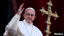 Paus Fransiskus melambai kepada umat setelah menyampaikan pesan "Urbi et Orbi" (kepada kota (Vatikan) dan seluruh dunia) dari balkon yang menghadap Lapangan Santo Petrus di Vatikan, 25 Desember 2016. 