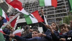 Schoolchildren wave Italian flags on a float in the Columbus Day parade in New York, Oct. 13, 2014. The parade is organized by the Columbus Citizens Foundation, and is billed as the world's largest celebration of Italian-American heritage and culture.
