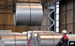FILE - A worker moves steel coils at the Thyssenkrupp steel factory in Duisburg, Germany, April 27, 2018. German reaction to the announcement of U.S. tariffs being placed on steel and aluminum imports was among the fiercest in Europe.