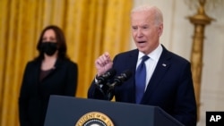 Vice President Kamala Harris listens as President Joe Biden speaks about the economy, in the East Room of the White House, May 10, 2021, in Washington. 
