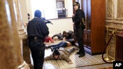 ប៉ូលិសសន្តិសុខការពារវិមានសភាឃាត់ខ្លួនបាតុករមួយចំនួនដែលបានសម្រុកចូលក្នុងវិមានសភា ក្នុងរដ្ឋធានីវ៉ាស៊ីនតោន ថ្ងៃទី៦ ខែមករា ឆ្នាំ២០២១។