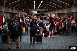 ภาพของผู้โดยสารที่สนามบินคาฮูลุย บนเกาะเมาวี รัฐฮาวาย ขณะรอเที่ยวบินเพื่อเดินทางออกจากเกาะ หลังมีการยกเลิกและเลื่อนเที่ยวบิน เพราะไฟป่าบนเกาะแห่งนี้