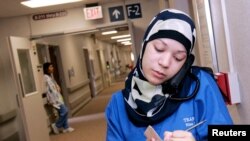 FILE - A woman takes notes on her next assignment as she works at a hospital in Detroit, August 21, 2007.
