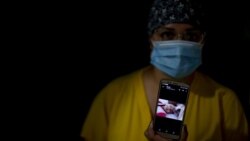 Marcela Brancati, a nurse, shows a picture of her 9-year old daughter Agostina, during her shift at the Ezeiza Hospital, southwest of Buenos Aires, Argentina, Thursday, July 16, 2020, amid the new coronavirus pandemic. (AP Photo/Natacha Pisarenko)