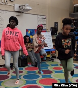 Tricia Gabriel, background, oversees dance practice at the nightly gathering of Genesis Youth Foundation, which helps children of refugees with evening programs to adjust to life in America, in Des Moines, Iowa, Jan. 28, 2019.