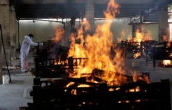 Flames rise from cremation pyres of victims of a fire that broke out in Vijay Vallabh COVID-19 hospital, at Virar, near Mumbai, India, Friday, April 23, 2021.