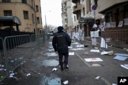 A policeman walks past the Turkish Embassy with broken window planes in Moscow, Russia, Nov. 25, 2015.