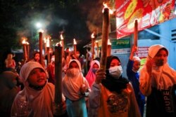 Anak-anak membawa obor untuk merayakan Idulfitri, menandai akhir bulan suci Ramadhan, di tengah pandemi COVID-19 di Jakarta, 12 Mei 2021. (Foto: REUTERS/Willy Kurniawan)