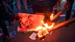 Protesters burn an image of Cambodian Prime Minister Hun Sen during a rally against the upcoming visit to Myanmar by the Cambodian leader, on Jan. 3, 2022, in Mandalay, Myanmar.