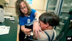 Seorang perawat AS, Starr Roden, melakukan vaksinasi campak terhadap seorang anak di kota Mount Vernon, Ohio (foto: dok). 