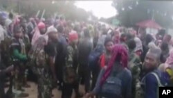 In this image taken from militant video released by the Islamic State group on Monday March 29, 2021, purporting to show fighters near the strategic north eastern Mozambique town of Palma.