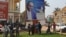 People stand under the poster of Central Africa Republic's President Francois Bozize in Bangui on December 28, 2012