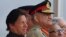 FILE - Pakistan's Army Chief Gen. Qamar Javed Bajwa, center, watches a parade with Prime Minister Imran Khan, left, and President Arif Alvi, in Islamabad, Pakistan, March 23, 2019.