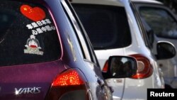 A Toyota car with a sticker attached to the rear window reading 'Japanese car, Chinese heart' is seen along a main road in central Beijing, October 9, 2012.