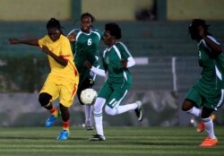Players of Al-tahadi (green kits) and Al-Difaa (yellow kits) soccer teams fight for the ball during Sudan's first women's league soccer match at the Khartoum stadium, Khartoum, Sudan, Sept. 30, 2019.