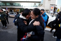 FILE - A high school student is cheered before taking the annual college entrance examinations, in front of an exam hall in Seoul, South Korea, Nov. 14, 2019.