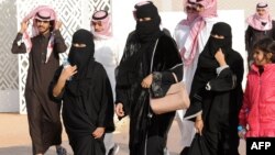 Dalam gambar yang diambil 19 Januari 2018, para perempuan dan pria Saudi sedang berjalan-jalan di Rumah, 160 kilometer arah timur Riyadh.
