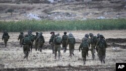 Israeli soldiers walk during an operation near Balata refugee camp in the West Bank city of Nablus,Tuesday, June 17, 2014. 