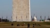 People walk near the Washington Monument, with the U.S. Capitol in the background, Dec. 26, 2018, as the partial government shutdown continues in Washington. A shutdown affecting parts of the federal government threatens to carry over into January.