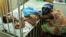 FILE - Hassana Ousmane rHassana Ousmane rests her head against the bed where 21-month-old Zeinab, suffering from diarrhea, rests, Princess Marie Louise Children's Hospital, Accra, April 25, 2012.
