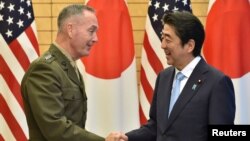 General Joseph Dunford, left, the chairman of the U.S. Joint Chiefs of Staff, shakes hands with Japan's Prime Minister Shinzo Abe at Abe's official residence in Tokyo, Japan, Aug. 18, 2017.
