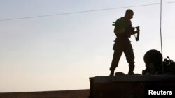 An Israeli soldier stands atop an armored personnel carrier (APC) near the border with the Gaza Strip, August 21, 2014.