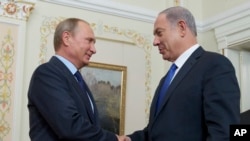 Russian President Vladimir Putin shakes hands with Israeli Prime Minister Benjamin Netanyahu, right, during their meeting at the Novo-Ogaryovo residence, outside Moscow, Sept. 21, 2015. 