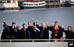 FILE - Captain Chesley "Sully" Sullenberger III, fourth from right, joins survivors and rescuers in a toast marking the anniversary of the event known as the "miracle on the Hudson," Jan. 15, 2014 in New York.