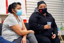 Graciela Uraga, left, a cleaning lady, and Blanca Cedillos, a nanny, react as they watch Joe Biden's presidential inauguration from the Workers Justice Center, an immigrant rights center, Jan. 20, 2021, in Brooklyn, N.Y.