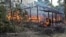 A Maungda hut burning in Western Myanmar. (Photo: Steve Sandford / VOA)
