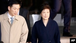 FILE - South Korea's ousted leader Park Geun-hye, right, leaves a prosecutor's office in Seoul, March 22, 2017.