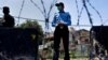 A police officer and paramilitary soldier stand guard at a checkpoint of a restricted area to help to contain the spread of new coronavirus, in Islamabad, Pakistan, June 13, 2020. 