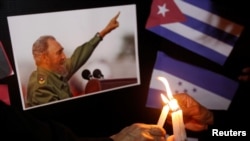 Warga menyalakan lilin di samping foto Fidel Castro, sebagai penghormatan untuk mendiang pemimpin revolusioner Kuba itu, di Tegucigalpa, Honduras (26/11). (Reuters/Jorge Cabrera)