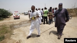 Pasukan keamanan Pakistan mengamankan lokasi serangan terhadap bisa penumpang di Karachi, Rabu (13/5).