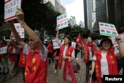 Supporters of visiting Zhang Dejiang, the chairman of China's National People's Congress, hold placards which read "Need livelihood, need stability", in Hong Kong on May 18, 2016.