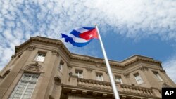 FILE - The Cuban flag is raised over their new embassy in Washington.