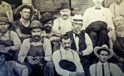 Historic photo of Jack Daniel (in white hat) seated next to George Green, the son of Nathan "Nearest" Green.