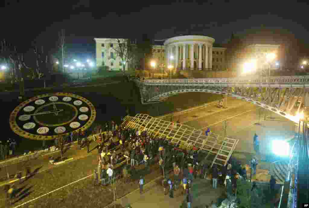 Ribuan demonstran di Kiev menghalangi pintu-pintu masuk ke gedung pemerintahan dan menyerukan perdana menteri dan kabinetnya supaya mundur. (AP/Sergei Grits)