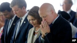 FILE - From right, New Orleans Mayor Mitch Landrieu and House Minority Leader Nancy Pelosi listen to an invocation at a wreath-laying ceremony at the Hurricane Katrina Memorial on the 10th anniversary of Hurricane Katrina in New Orleans, Aug. 29, 2015.