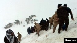 Turkish soldiers and locals try to rescue people trapped under avalanche in Bahcesaray in Van province, Turkey, 