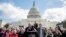 Senate Minority Leader Sen. Chuck Schumer, D-N.Y., holds hands with student activist Matt Post, right, during a student gun control advocates rally outside the Capitol Building in Washington, March 14, 2018. Students walked out of school to protest gun violence in the biggest demonstration yet of the student activism that has emerged in response to last month's massacre of 17 people at Florida's Marjory Stoneman Douglas High School. 