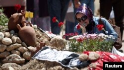 A woman mourns at graves for miners who died in Tuesday's mine disaster, at a cemetery in Soma, Turkey, May 18, 2014. 