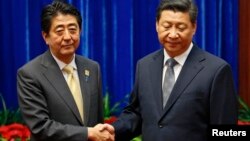 China's President Xi Jinping (R) shakes hands with Japan's Prime Minister Shinzo Abe during their meeting at the Great Hall of the People, on the sidelines of the Asia Pacific Economic Cooperation (APEC) meetings, in Beijing, November 10, 2014.