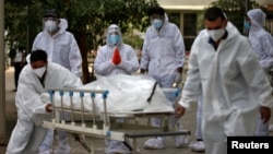 Petuga medis membawa jenazah korban meninggal akibat COVID-19 di Ahmedabad, India, Sabtu (8/5). 