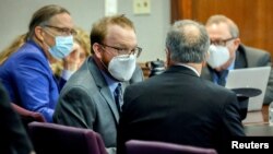 FILE PHOTO: Travis McMichael, left, speaks with his attorney Bob Rubin, right, during the sentencing of his and his father Greg McMichael and neighbor, William Bryan, Jan. 7, 2022, in Brunswick, Ga.