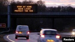 FILE - A government public health information message is seen on a roadside sign, amidst the spread of the coronavirus pandemic, near Milnathort, Scotland, Jan. 5, 2021. 